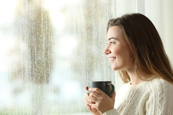 looking through window at heavy rain and peace of mind with sump pump install