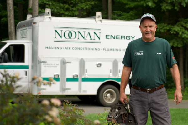 Noonan Energy licensed plumber in front of the service van