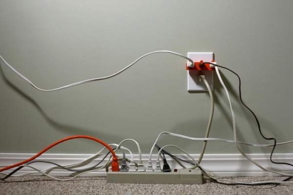 electrical outlet overloaded with extension cords