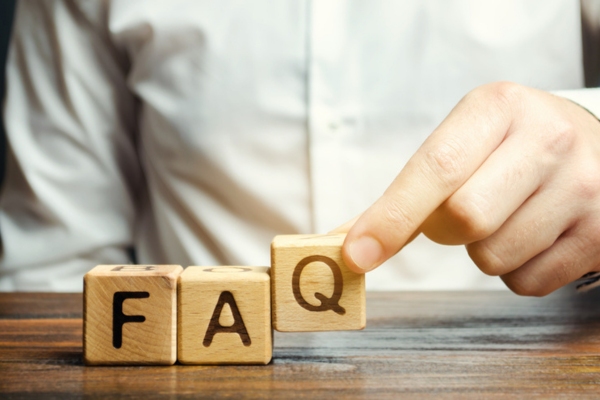 man spelling FAQ using wooden letter cubes depicting questions about leaky water heater