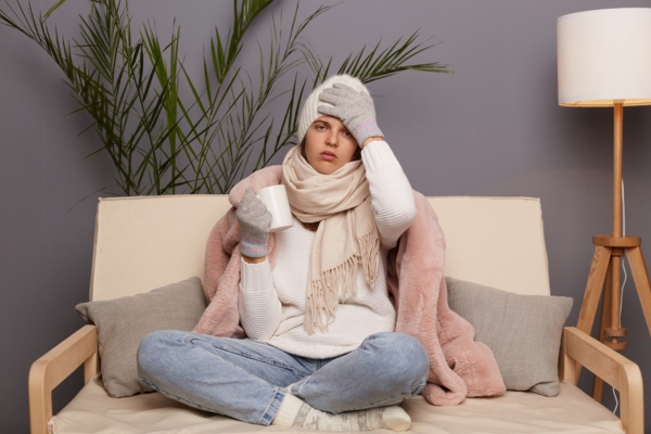 woman fully dressed for winter indoors depicting uneven heating problems at home