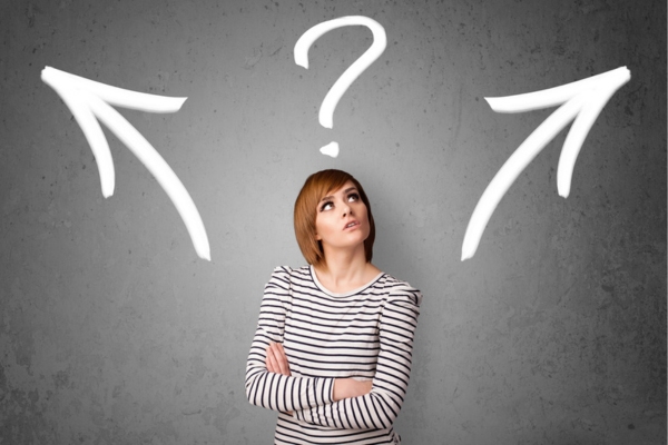 woman looking up at a question mark with arrows on different side depicting choosing a heating system