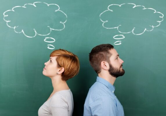 two people with thought bubble drawn on a chalkboard depicting thinking about boiler and furnace differences